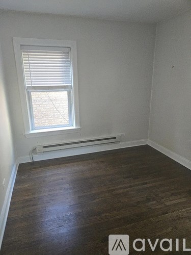 A room with a window and wooden floor.