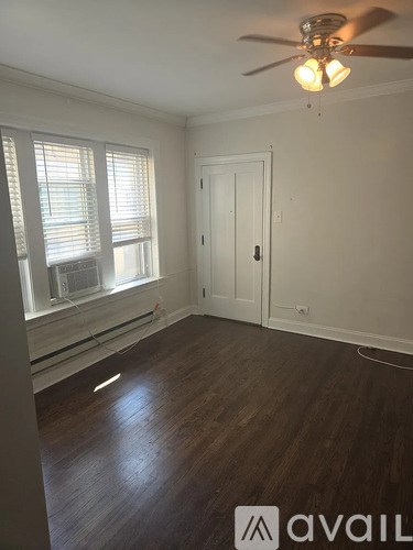 A room with a ceiling fan and wooden floors.