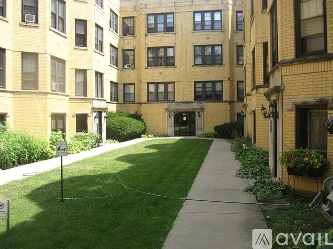 A grassy area in front of a building with a sign that says "AVAILABLE".