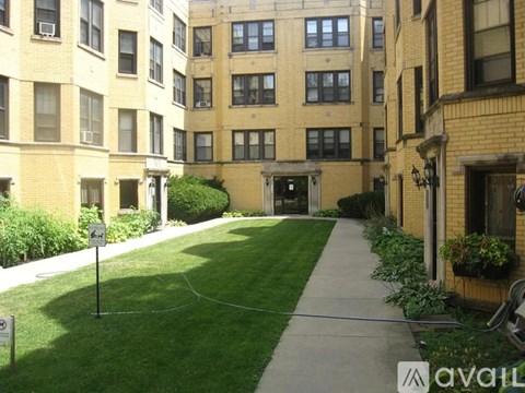 A grassy area in front of a building with a sign that says "AVAILABLE".