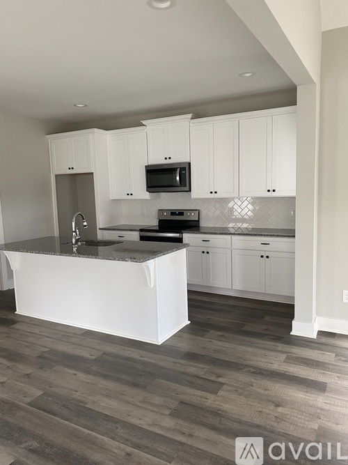 A kitchen with white cabinets and a granite countertop.