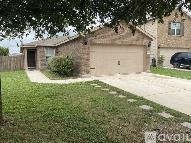 A house with a brown garage door is surrounded by a green lawn.