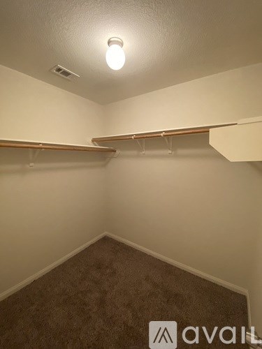 A room with a carpeted floor and a light on the ceiling.