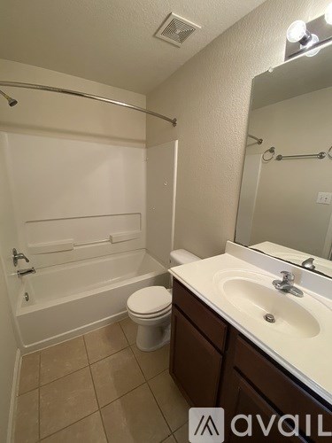 A bathroom with a toilet, sink, and bathtub.