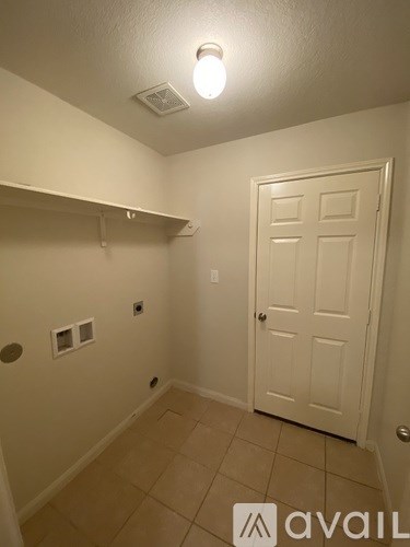A small, empty room with a door and a light on.