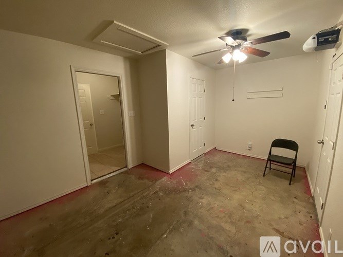 A room with a chair and a ceiling fan.