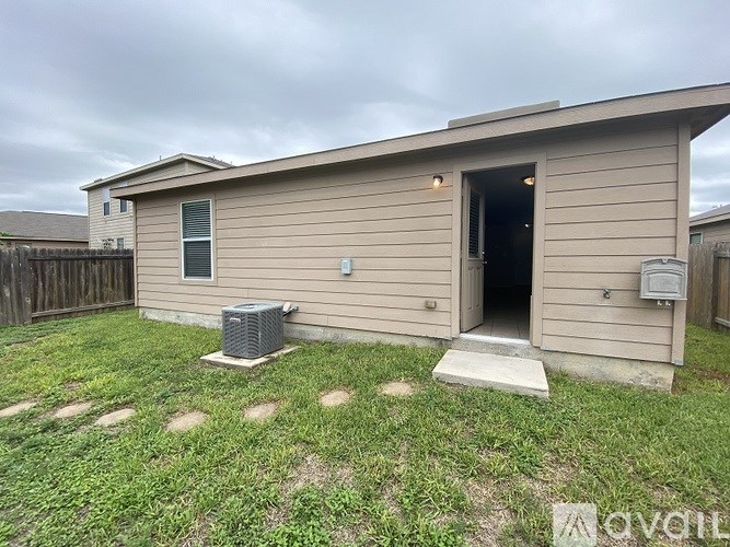 A small house with a door open and a window on the side.