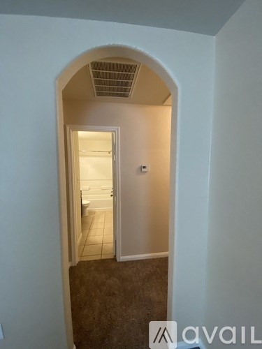A hallway with a carpeted floor and a white door.