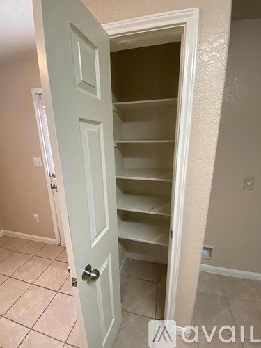 A white door is open to a room with a white wall.