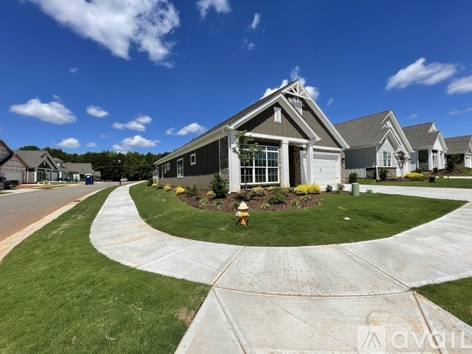 A house with a well-manicured lawn and a driveway in front.