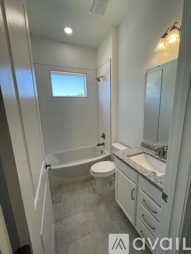A bathroom with a toilet, sink, and shower.