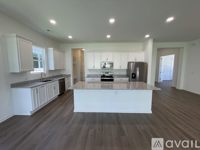 A spacious kitchen with white cabinets and a central island.