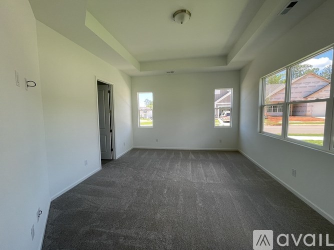 A spacious room with a carpeted floor and a door leading to another room.