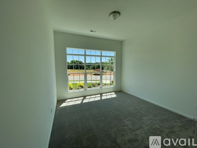 A room with a large window overlooking a parking lot.