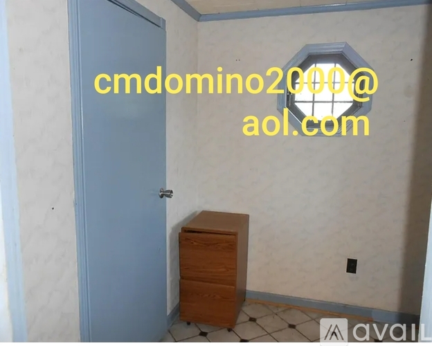 A room with a blue door and a wooden chest of drawers.