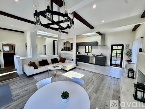 A modern living room with a white sofa and a large chandelier.