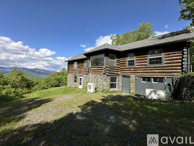 A wooden house with a mountain view in the background.