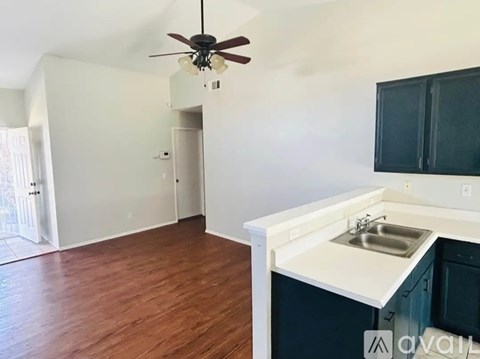 A kitchen with a sink and a ceiling fan.
