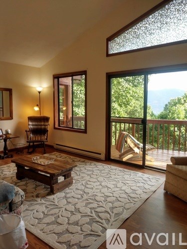 A living room with a wooden coffee table and a large window.