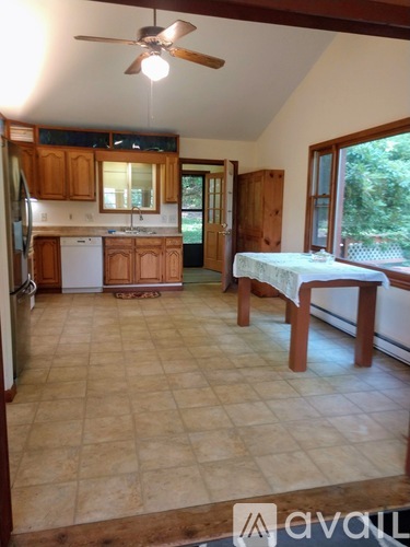 A kitchen with wooden cabinets and a white dishwasher.
