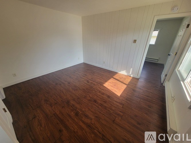 A room with wooden flooring and white walls.