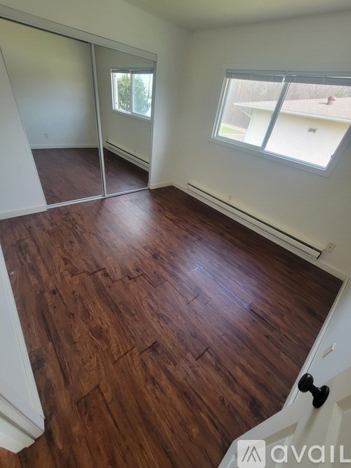 A room with wooden flooring and a sliding glass door.