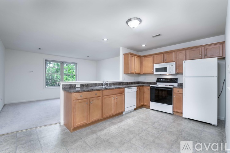 A kitchen with white appliances and wooden cabinets.