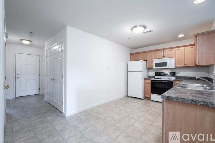 A kitchen with white cabinets and a marble countertop.