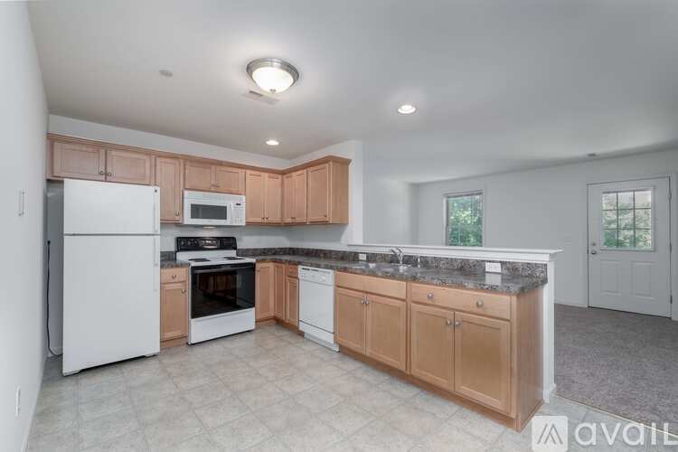 A kitchen with wooden cabinets and a white refrigerator.