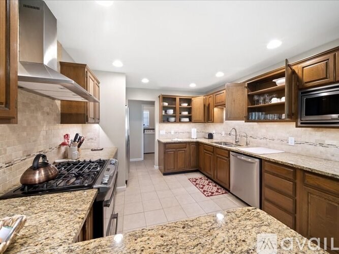 A kitchen with granite countertops and wooden cabinets.