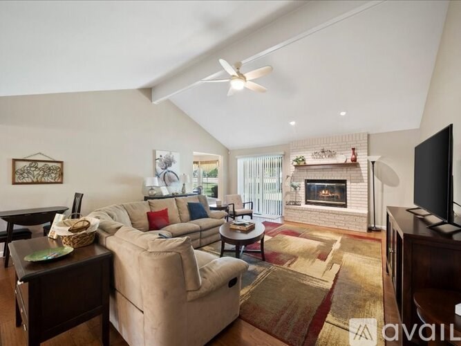 A living room with a fireplace and a television.