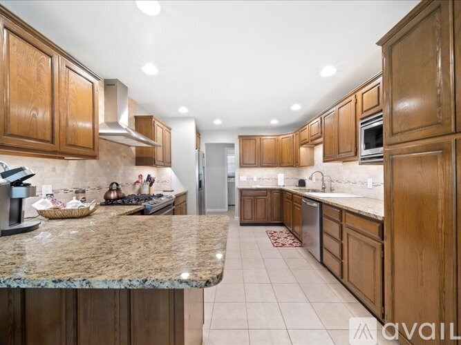 A kitchen with wooden cabinets and granite countertops.