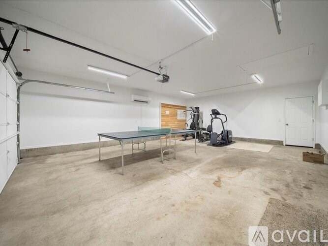 A spacious garage with a table and chairs in the middle.