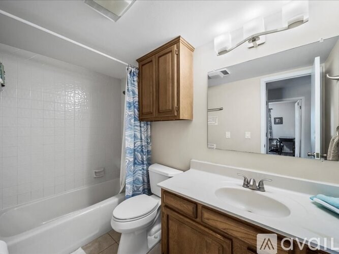 A white toilet sits next to a white sink in a bathroom.
