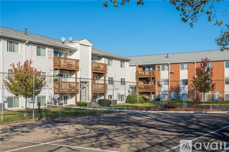 A sunny day at a residential complex with apartments and a parking lot.
