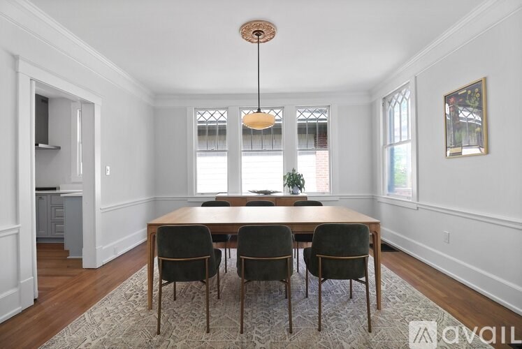A dining room with a table and chairs.