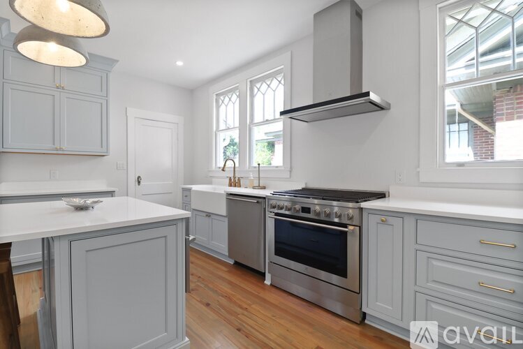A modern kitchen with a stainless steel oven and grey cabinets.
