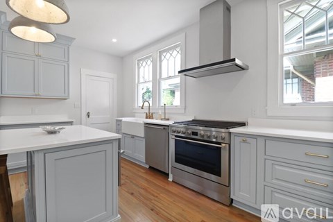 A modern kitchen with a stainless steel oven and grey cabinets.
