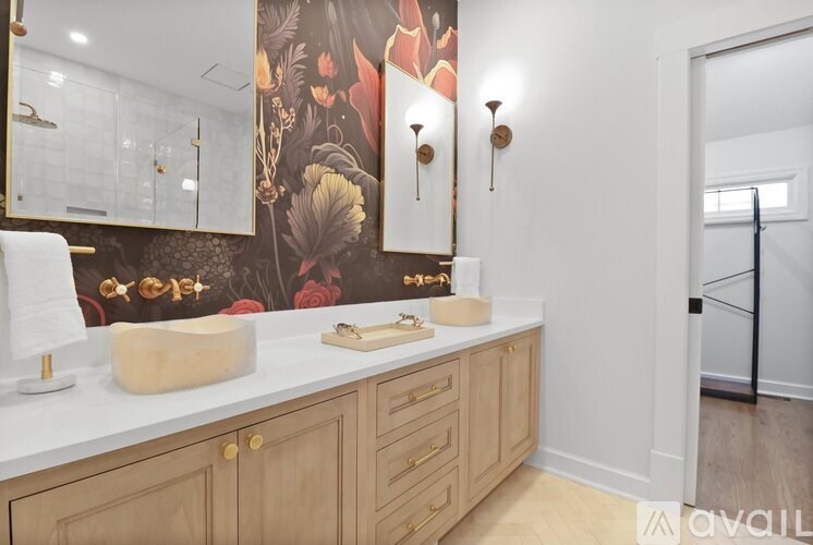 A bathroom with a floral wallpaper and wooden cabinets.