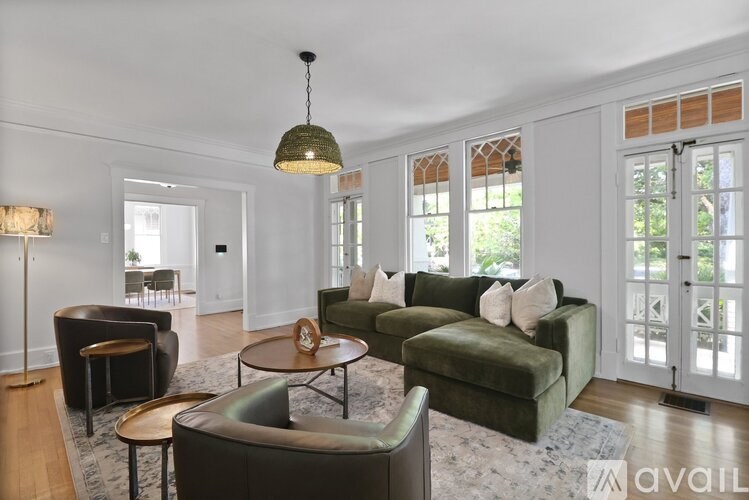 A living room with a green couch and a lamp.