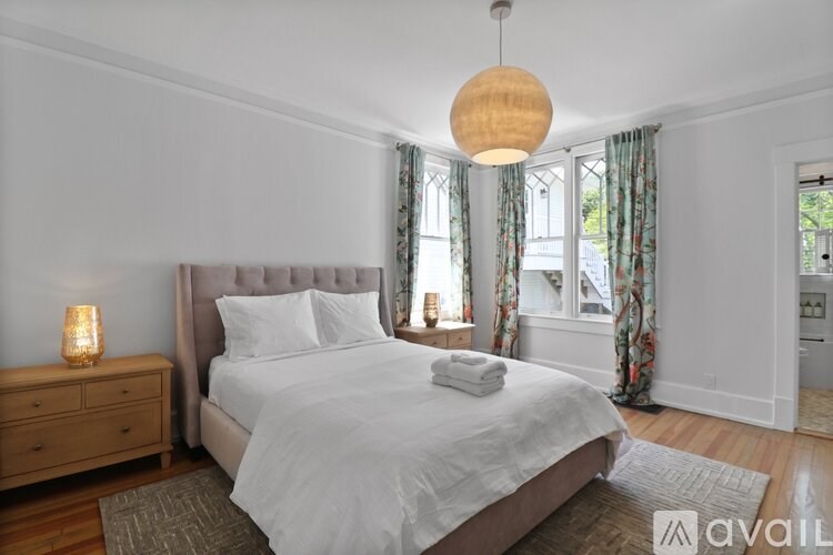 A bedroom with a large bed and a wooden dresser.