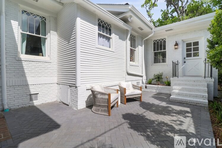 A white house with a patio and a white chair.