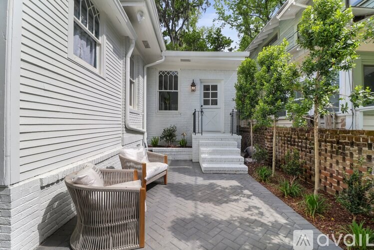 A white house with a patio and a wicker chair.