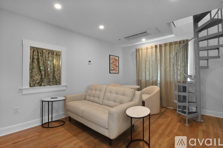 A living room with a beige couch, a small table, and a painting on the wall.
