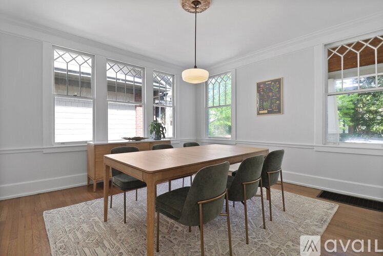 A dining room with a wooden table and chairs.