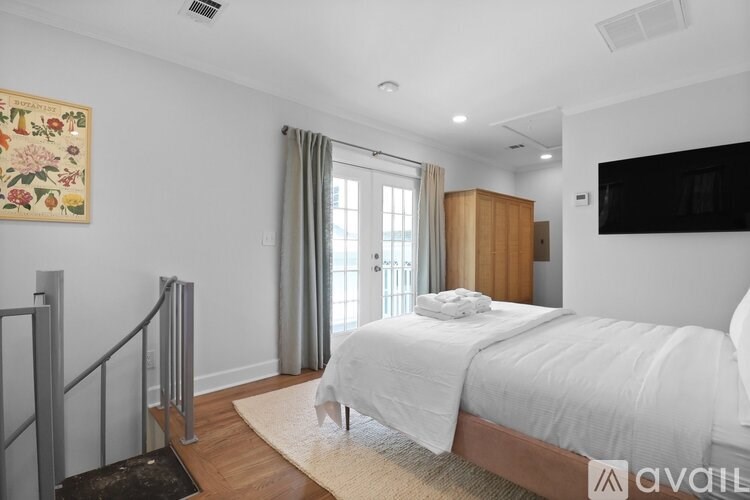 A bedroom with a large bed and a painting on the wall.