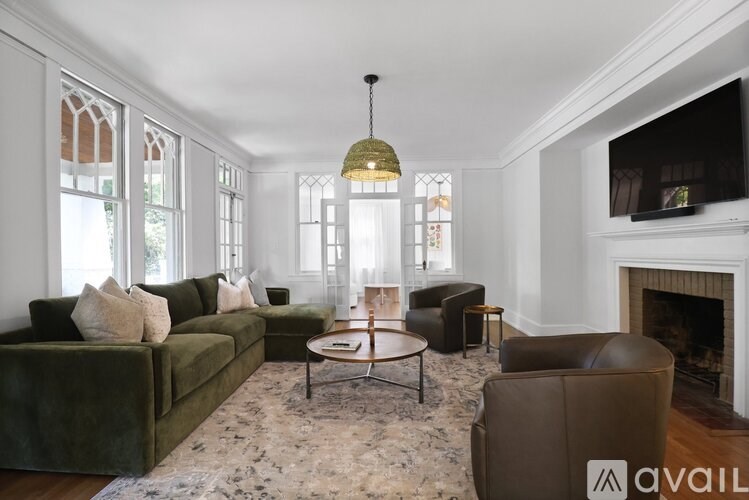 A living room with a green couch, a coffee table, and a fireplace.