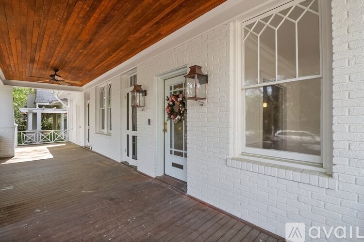 A porch with a wooden ceiling and white walls.