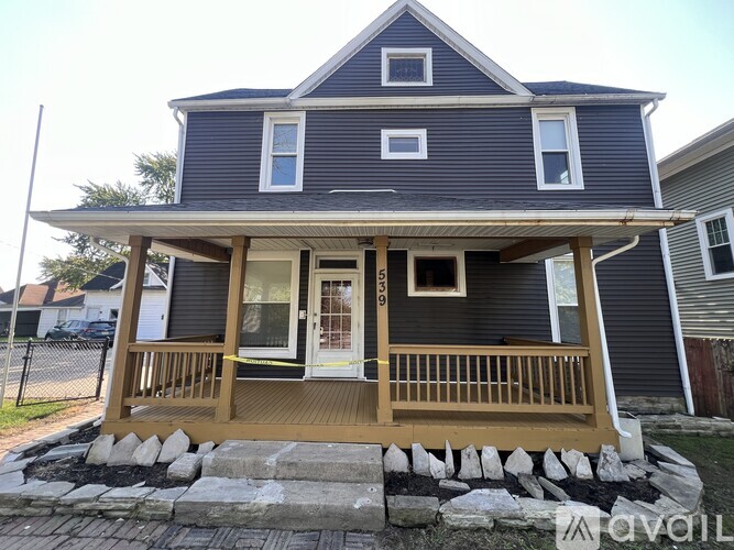 A house with a grey exterior and a wooden porch.