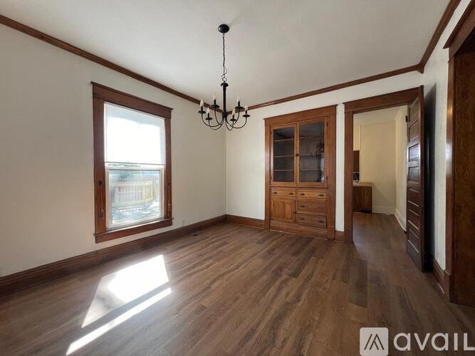A room with wooden floors and a chandelier.